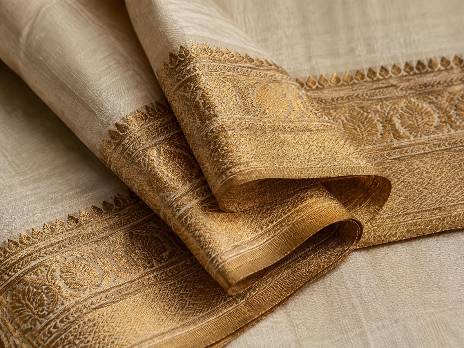 Macro detail of antique gold zari brocade bordering ivory raw silk